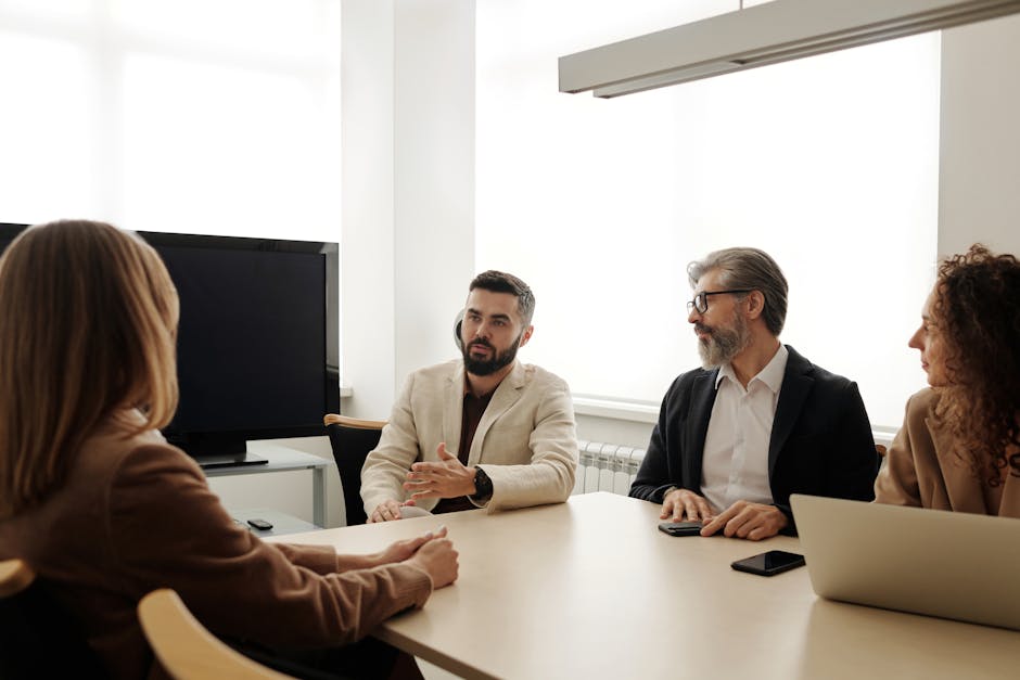 A diverse group of business professionals engaged in a meeting in an office setting