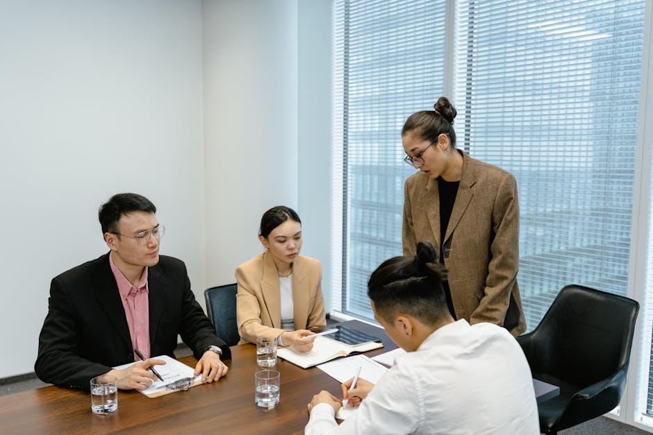A group of business professionals engaged in a team meeting in a modern office setting